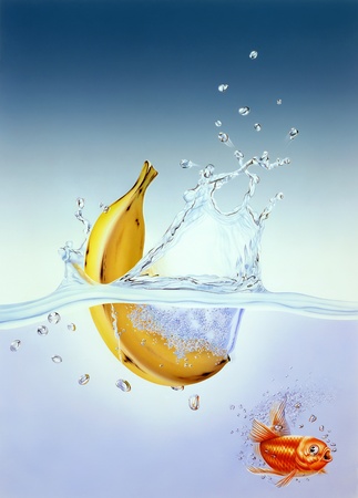 banana splashing into water with gold fish scaredの写真素材