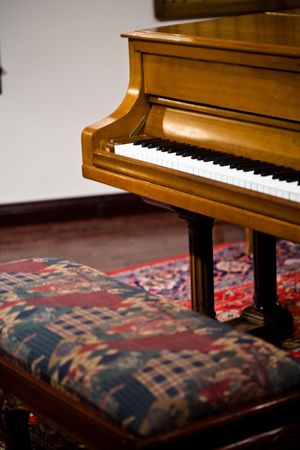 An oak piano with a fabric covered benchの写真素材