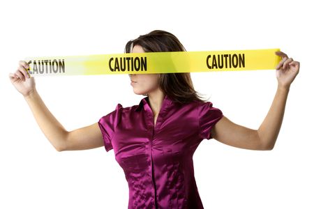 Profile of woman holding yellow caution tape over her eyesの写真素材