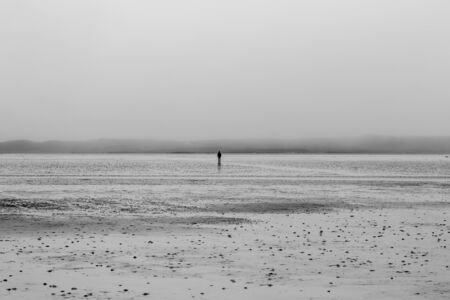 A lone figure in the distance walking to the island of Vallay from North Uist, at low tideの写真素材