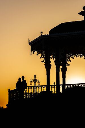 A silhouetted romantic couple with a beautiful sunset behindの写真素材