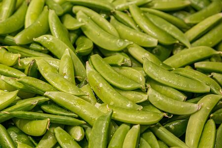 A full frame photograph of sugar snap peas for sale on a market stallの写真素材