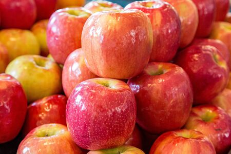 Red apples piled up for sale on a farmers market stallの写真素材