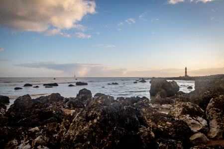 Looking out over the rocky beach near Eastbourne at low tide, towards Beachy Head Lighthouseの写真素材