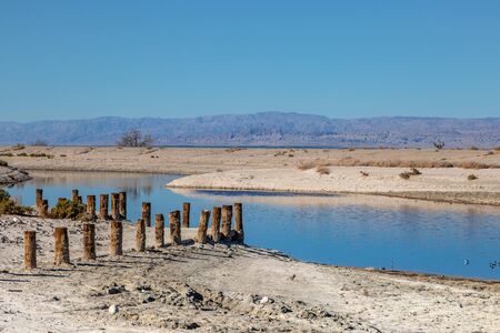 The shore of the Salton Sea with remains of an old built structureの写真素材