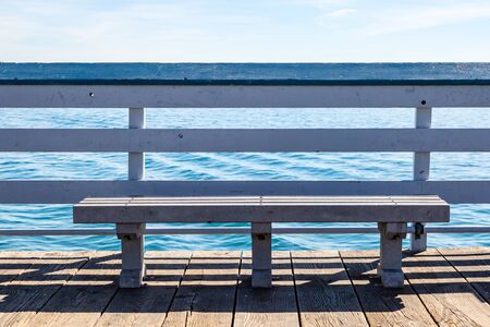 A bench on San Clemente Pier in California, overlooking the oceanの写真素材