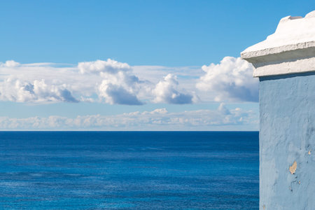 Looking out over the ocean, with part of a blue and white building in the foreground