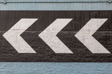 Painted arrows pointing the way, on the wall of an urban buildingの写真素材