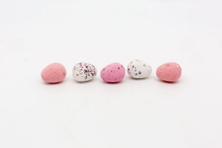 A row of pink and white Easter eggs against a white background