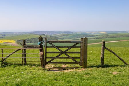 A wooden gate and a fence, in the South Downs National Park in Sussexの写真素材