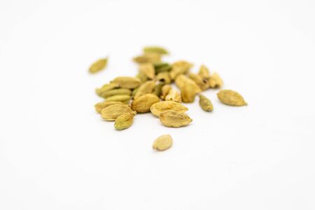 Whole cardamom pods with a shallow depth of field, against a white backgroundの写真素材