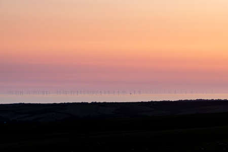 Looking out over the ocean at sunset, from Firle Beacon in Sussexの写真素材