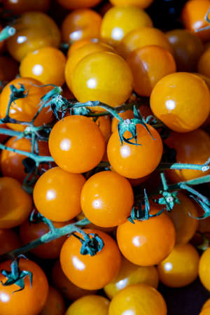A full frame photograph of ripe cherry tomatoes for sale on a farmers market stallの写真素材