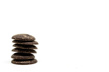Dark Chocolate Buttons to the left of the frame against a White Backgroundの写真素材