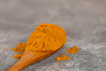A close up of a spoonful of powdered turmeric, with a shallow depth of fieldの写真素材