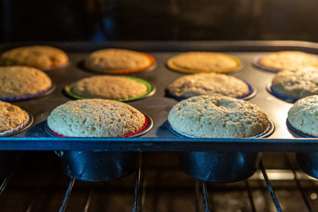 Cakes baking in an oven, with a shallow depth of field