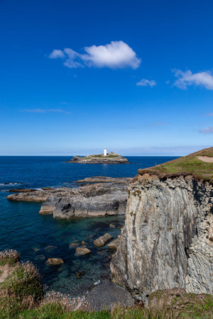 A view over the rugged Cornish coastline towards Godrevy Lighthouseの写真素材