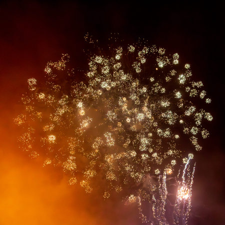 Looking up at exploding fireworks against a night sky