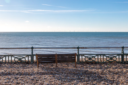 A view over the promenade at Brighton with pebbles washed up following a high tideの写真素材