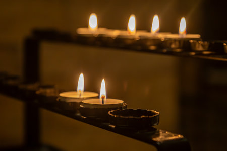 Lit tea lights in a church, with a shallow depth of fieldの写真素材
