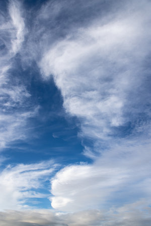 Looking up at fluffy clouds and a blue skyの写真素材