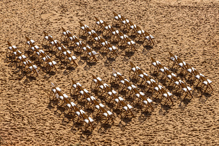 A high angle view of chairs set out on a sandy beach for a weddingの写真素材