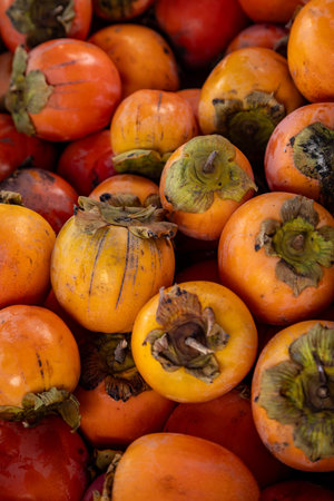 An abundance of persimmon fruit displayed on a Portuguese market stall