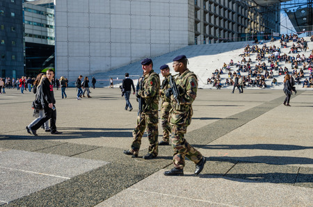 Paris, France, October 27, 2014 - Soldiers patrol La Grande Arche where government and business employees as well as tourists eat lunch on its steps. La Defense is a major commercial center in the city.のeditorial素材