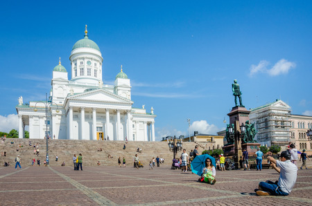 Helsinki, Finland, August 8, 2014 ? A tourist takes a photograph of his companion at the Helsinki Cathedral which is a central tourist attraction in the Finnish capital.のeditorial素材