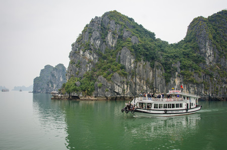Halong Bay, Vietnam, February 12, 2015 - A boat carrying tourists cruises among hundreds a small islands in Halong Bayのeditorial素材