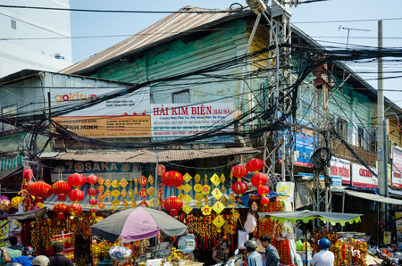 Saigon, Vietnam, February 7, 2015 ? People on the street are oblivious to the dangers of the tangled mess of power and telecommunications cables overhead.  Although the cables pose a threat of a major fire, efforts to bury them underground have failed.のeditorial素材