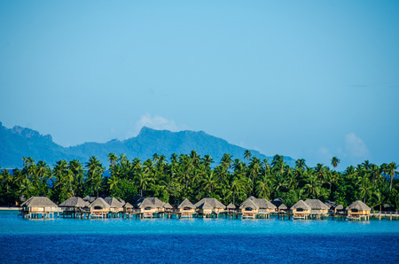 Luxury overwater bungalows with view of amazing blue and turquoise colors of the lagoon under a sunny sky.の写真素材