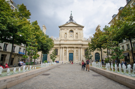Paris, France, August 18, 2015 - People are walking beside the water fountains of Place de la Sorbonne in front of Eglise de la Sorbonne on a summer afternoon.のeditorial素材
