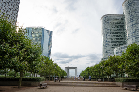 Paris, France, August 11, 2015 - People walk along the pedestrian walkway, the central esplanade at the vast government and commercial complex at La Defense with La Grande Arche in the distance.のeditorial素材