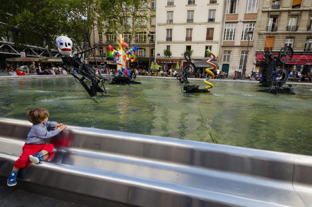 PARIS - FRANCE, SEPTEMBER 3, 2015: Boy gazes at the whimsical colorful sculptures at the Stravinsky Fountain which represent the music of Russian composer Igor Stravinskys The Rite of Spring.のeditorial素材
