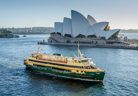 Australia, November 2, 2016 - A passenger ferry passes in front of the Sidney Opera House. a multi-venue performing arts center, designed by Danish architect Jorn Utzon.のeditorial素材