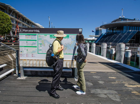 Sidney, Australia, November 2, 2016 - Tourists check out the map at the promenade at Darling Harbour, one of the citys largest dining, shopping and entertainment precincts and a popular destination for visitors.のeditorial素材