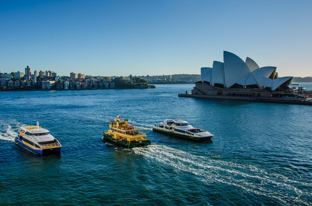 Sidney, Australia, November 2, 2016 - Passenger ferries pass in front of the Sidney Opera House, a multi-venue performing arts center, designed by Danish architect Jorn Utzon.のeditorial素材