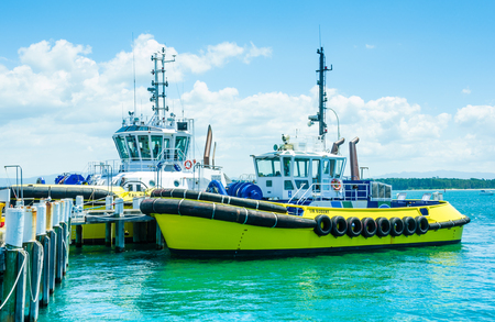 Tauranga, New Zealand, December 11, 2017 - Colorful pilot tug boats wait at anchor to accompany cruise ships and freighters entering and leaving the largest and busiest port in the country.のeditorial素材