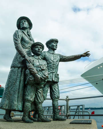 Cobh, Ireland, August 20, 2018 - The famous statue of 17-year-old Annie Moore and her brothers looking out onto the harbor commemorates the first immigrants processed at Ellis Island in 1892.のeditorial素材