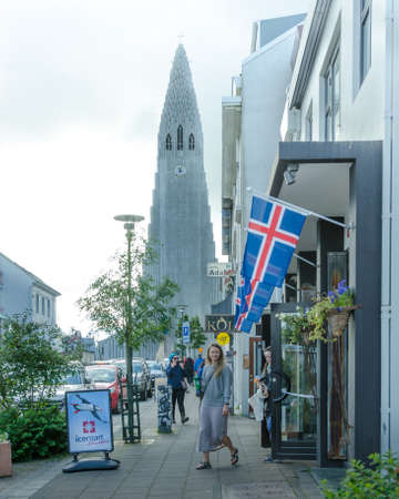 Reykjavik, Iceland, August 28, 2018 - Tourists walk along the main avenue in the city crowded with shops and restaurants down the hill from the Hallgrimskirja Church in the distance.のeditorial素材