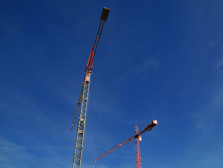 Two cranes against blue sky