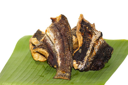 Fried salted fish on banana leaf isolated on white background.の写真素材