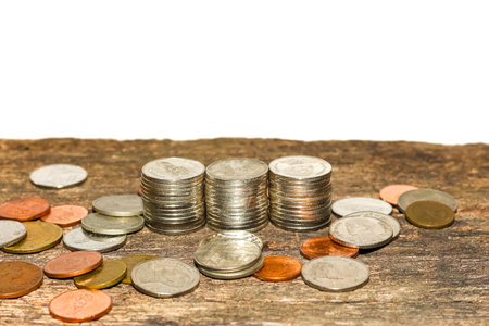 Coins on old wooden table with white background, business concept.の写真素材