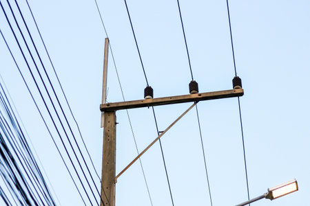 electricity post with blue sky background, power transmission lines and wiresの写真素材