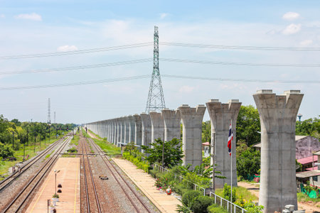 Railway and high-voltage power line with blue sky background