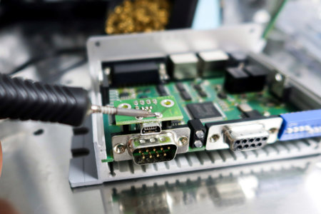 Close-up of electronic circuit board with a soldering iron.の写真素材