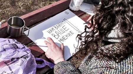 a woman writes on paper your opinion is important to us colorの写真素材