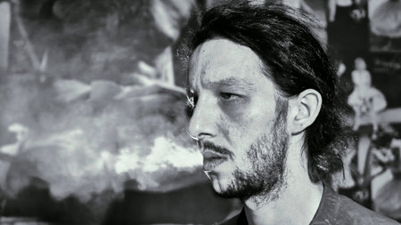 Man close-up releases smoke black and white