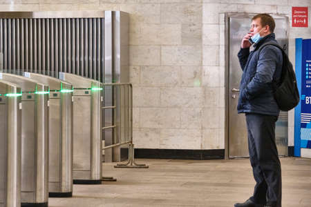 Russia Moscow June 2020. Moscow metro. a man stands in front of the turnstiles at the entrance and speaks on the phone. coronavirus epidemic in Russia. viral risk of infection.のeditorial素材